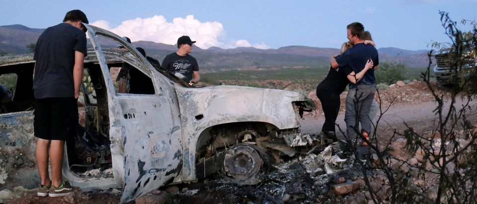 Relatives of slain members of Mexican-American families belonging to Mormon communities observe the burnt wreckage of a vehicle where some of their relatives died, in Bavispe, Sonora state, Mexico November 5, 2019. REUTERS/Jose Luis Gonzalez