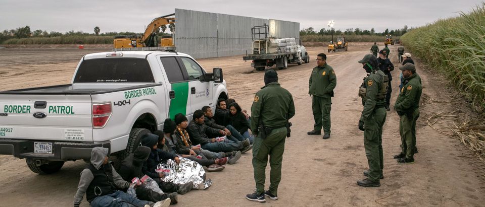 U.S. Border Patrol agents detain undocumented immigrants caught near a section of privately-built border wall under construction on Dec. 11, 2019 near Mission, Texas. (Photo by John Moore/Getty Images)