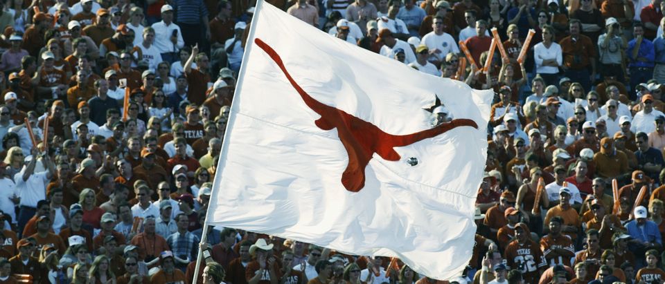 A Texas Longhorns cheerleader runs with the school banner during the Red River Shootout against the Oklahoma Sooners at the Cotton Bowl on October 12, 2002 in Dallas, Texas. (Ronald Martinez/Getty Images)