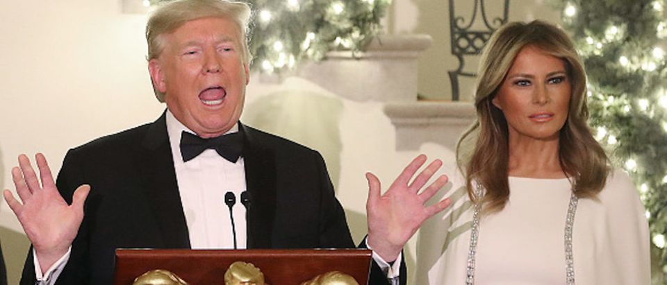 President Donald Trump speaks as first lady Melania Trump looks during a Congressional Ball in the Grand Foyer of the White House on December 12, 2019