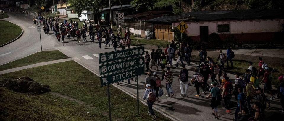 Hondurans walk along a road as they take part in a new caravan of migrants, set to head to the United States, in San Pedro Sula