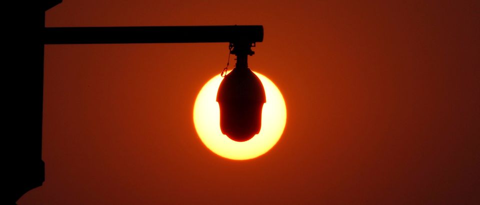 FILE PHOTO: Rising sun is seen behind surveillance cameras before a military parade marking the 70th founding anniversary of People's Republic of China