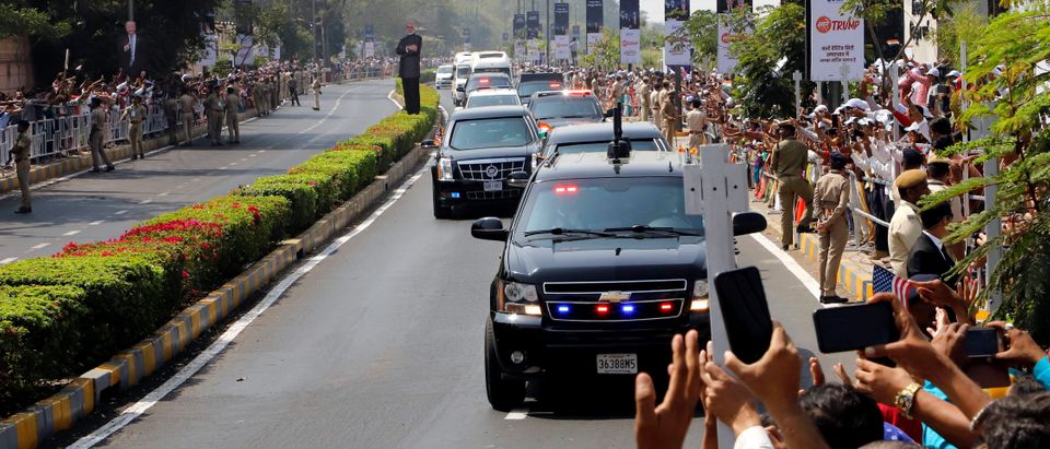 People wave as a motorcade transporting U.S. President Donald Trump and first lady Melania Trump passes enroute to Gandhi Ashram in Ahmedabad, India, February 24, 2020. (REUTERS/Stringer)