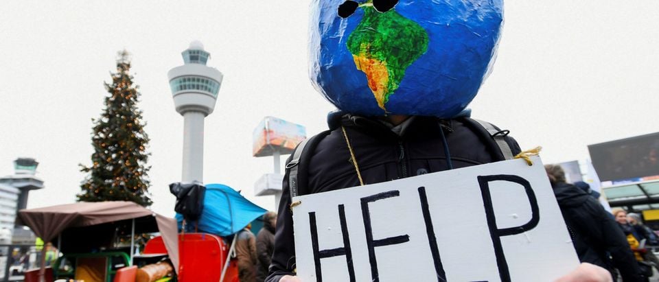 FILE PHOTO: A man demonstrates as Greenpeace stages a climate protest at Amsterdam Schiphol Airport in Schiphol