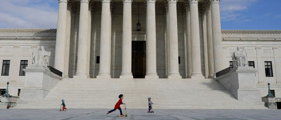 Children ride scooters across the plaza at the United States Supreme Court, following the government's notice to halt all building tours due to the (COVID-19) coronavirus, on Capitol Hill in Washington