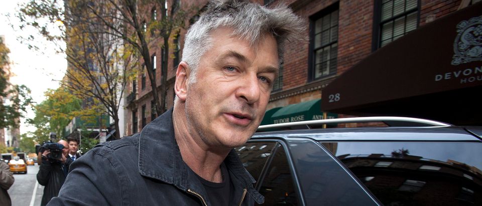 Actor Alec Baldwin shoves a photographer and tells him to move out of his way after he arrived in his SUV at the building where he lives in New York November 15, 2013. REUTERS/Carlo Allegri