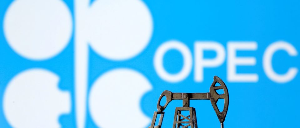 A 3D printed oil pump jack is seen in front of displayed Opec logo in this illustration picture