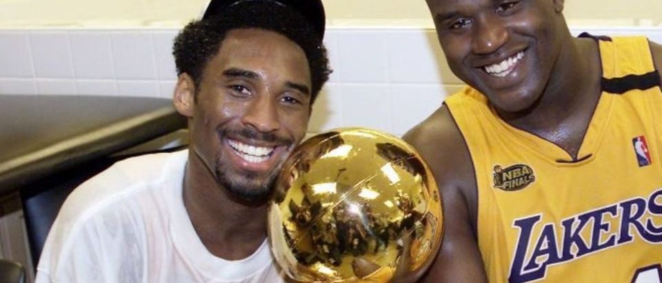 Kobe Bryant (L) of the Los Angeles Lakers holds the Larry O'Brian trophy as teammate Shaquille O'Neal (L) hold the MVP trophy after winning the NBA Championship against Indiana Pacers 19 June, 2000, after game six of the NBA Finals at Staples Center in Los Angeles, CA. The Lakers won the game 116-111 to take the NBA title 4-2 in the best-of-seven series. (Photo by AFP via Getty Images)