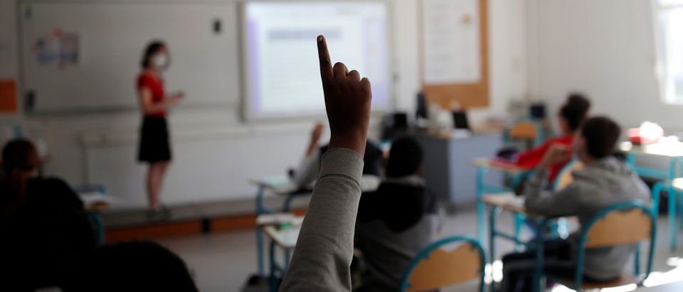 A student raises his hand in a classroom at the College Rosa Parks school during its reopening in Nantes as a small part of French shoolchildren head back to their schools with new rules and social distancing during the outbreak of the coronavirus disease (COVID-19) in France, May 20, 2020. REUTERS/Stephane Mahe)