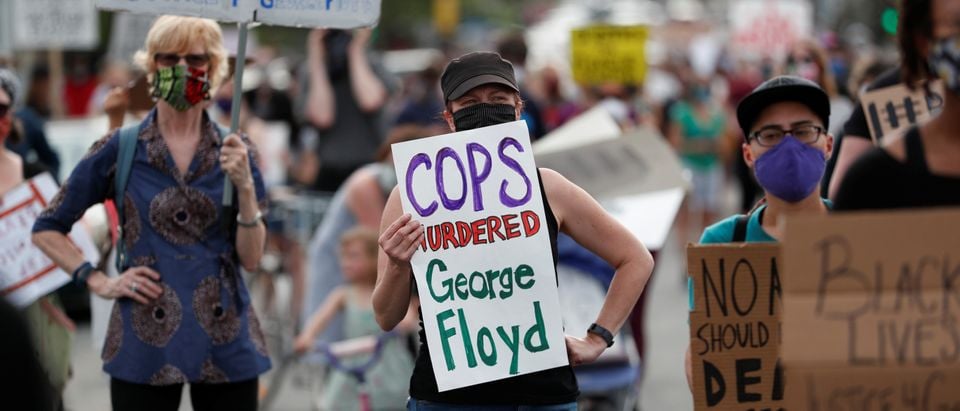 Protesters gather at the scene where George Floyd, an unarmed black man, was pinned down by a police officer kneeling on his neck before later dying in hospital in Minneapolis, Minnesota, U.S. May 26, 2020. REUTERS/Eric Miller