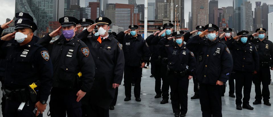 Police officers from the NYPD salute as the U.S. Navy hospital ship USNS Comfort departs Pier 90 in Manhattan. REUTERS/Lucas Jackson