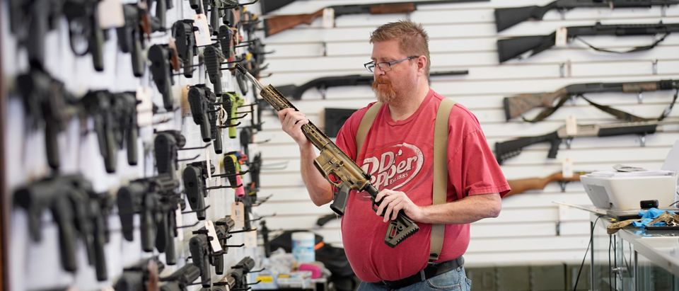 A worker inspects an AR-15 gun at Davidson Defense in Orem, Utah on March 20, 2020. - Gun stores in the US are reporting a surge in sales of firearms as coronavirus fears trigger personal safety concerns. (Photo by GEORGE FREY/AFP via Getty Images)