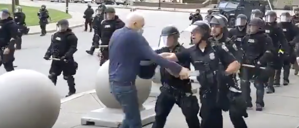 Elderly protestor is shoved to ground by Buffalo police officers.