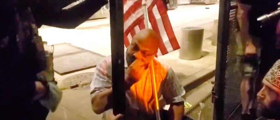 A man holding an American flag urged rioters to stop destroying things. (Screenshot Twitter Jorge Ventura)