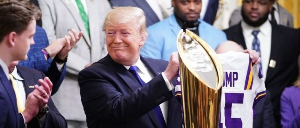 Tigers Quarterback Joe Burrow gives US President Donald Trump a team jersey as they take part in an event honoring the 2019 College Football National Champions, the Louisiana State University Tigers, in the East Room of the White House in Washington, DC, on January 17, 2020. (Photo by MANDEL NGAN/AFP via Getty Images)