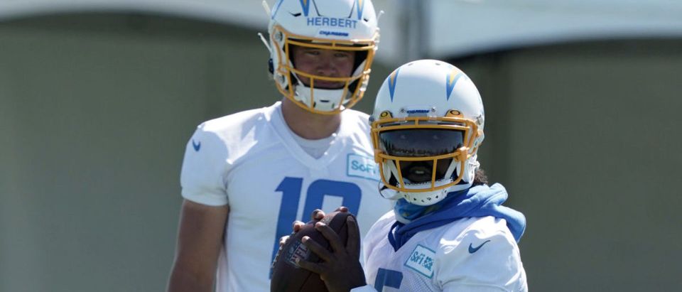 Aug 14, 2020; Costa Mesa, California, USA; Los Angeles Chargers quarterback Tyrod Taylor (5) throws the ball as quarterback Justin Herbert (10) watches during training camp at the Jack Hammett Sports Complex. Mandatory Credit: Kirby Lee-USA TODAY Sports via Reuters