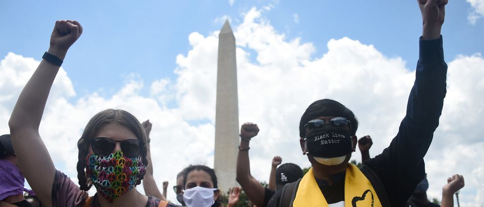 Demonstrators raise their fists as they take part in a Juneteenth march and rally by the Washington Monument in Washington, DC, on June 19, 2020. - The US marks the end of slavery by celebrating Juneteenth, with the annual unofficial holiday taking on renewed significance as millions of Americans confront the nation's living legacy of racial injustice. (Photo by Olivier DOULIERY / AFP) (Photo by OLIVIER DOULIERY/AFP via Getty Images)