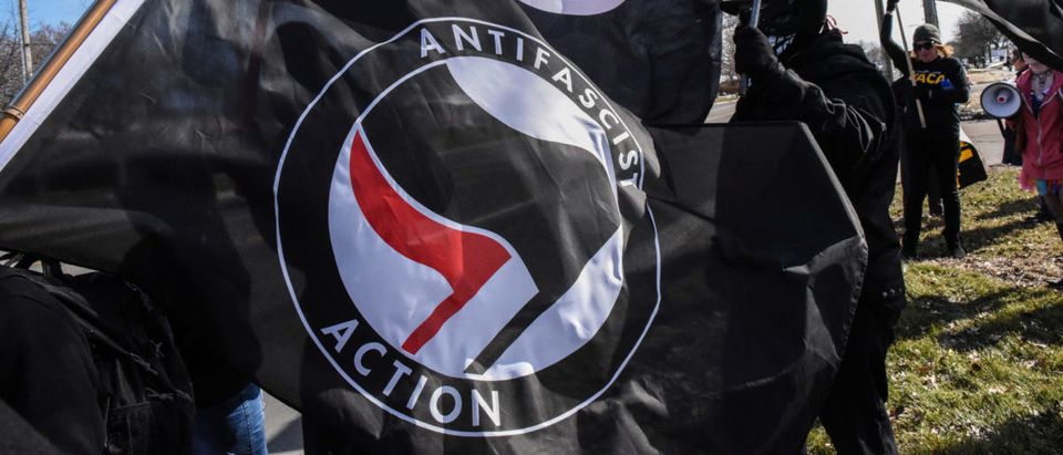 Members of the Great Lakes anti-fascist organization (Antifa) fly flags during a protest against the Alt-right outside a hotel in Warren, Michigan