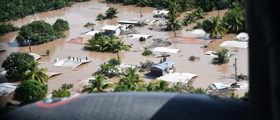 Hondurans stand on rooftops surrounded by the floodwaters of Hurricane Eta