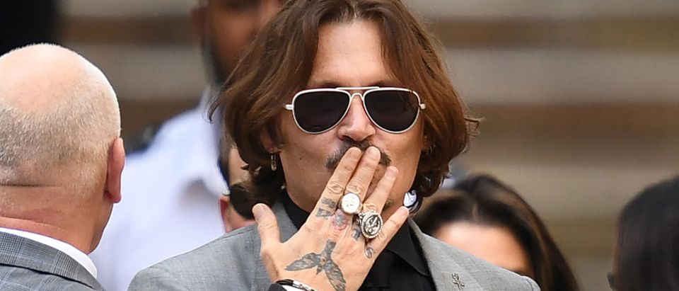 US actor Johnny Depp gestures as he leaves the High Court after the final day of his libel trial against News Group Newspapers (NGN), in London, on July 28, 2020. - Johnny Depp grabbed a teddy bear from a fan and waved to a crush of supporters Tuesday as he entered London's High Court for the final day of his three-week libel trial against Britain's The Sun tabloid over allegations he beat ex-wife Amber Heard. Depp rejects accusations of repeatedly hurting the 34-year-old actress over a three-year span that ended with Heard's 2016 decision to get a restraining order and file for divorce. (Photo by DANIEL LEAL-OLIVAS/AFP via Getty Images)