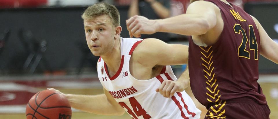 Dec 15, 2020; Madison, Wisconsin, USA; Wisconsin Badgers guard Brad Davison (34) works the ball against Loyola Ramblers guard Tate Hall (24) during the second half at the Kohl Center. Mandatory Credit: Mary Langenfeld-USA TODAY Sports via Reuters