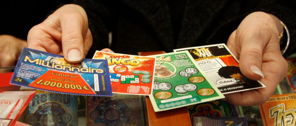 A shop keeper shows off lottery tickets at a tobacconist shop in Marseille