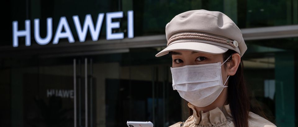 A woman walks past a shop for Chinese telecoms giant Huawei in Beijing on May 25, 2020. (Photo by NICOLAS ASFOURI / AFP) (Photo by NICOLAS ASFOURI/AFP via Getty Images)