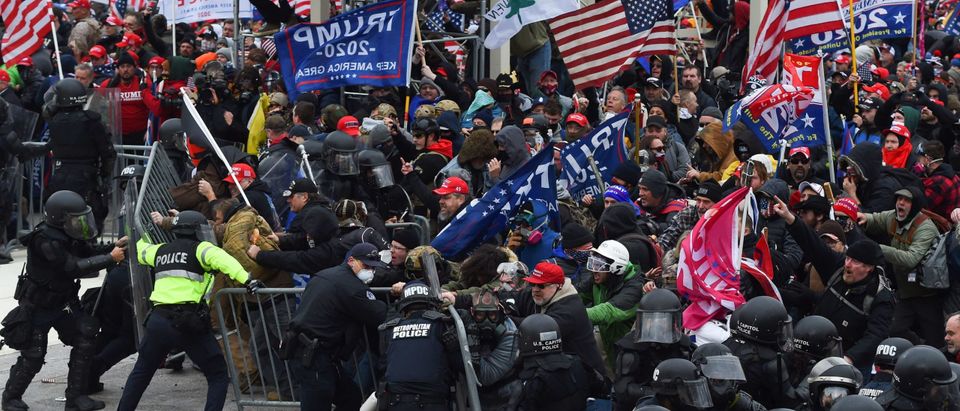 TOPSHOT - Trump supporters clash with police and security forces as they push barricades to storm the US Capitol in Washington D.C on January 6, 2021. - Demonstrators breeched security and entered the Capitol as Congress debated the a 2020 presidential election Electoral Vote Certification. (Photo by ROBERTO SCHMIDT / AFP) (Photo by ROBERTO SCHMIDT/AFP via Getty Images)