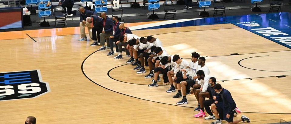 Mar 20, 2021; Indianapolis, Indiana, USA; Colorado Buffaloes players and staff kneel during the national anthem during the first round of the 2021 NCAA Tournament against the Georgetown Hoyas at Hinkle Fieldhouse. Mandatory Credit: Patrick Gorski-USA TODAY Sports via Reuters