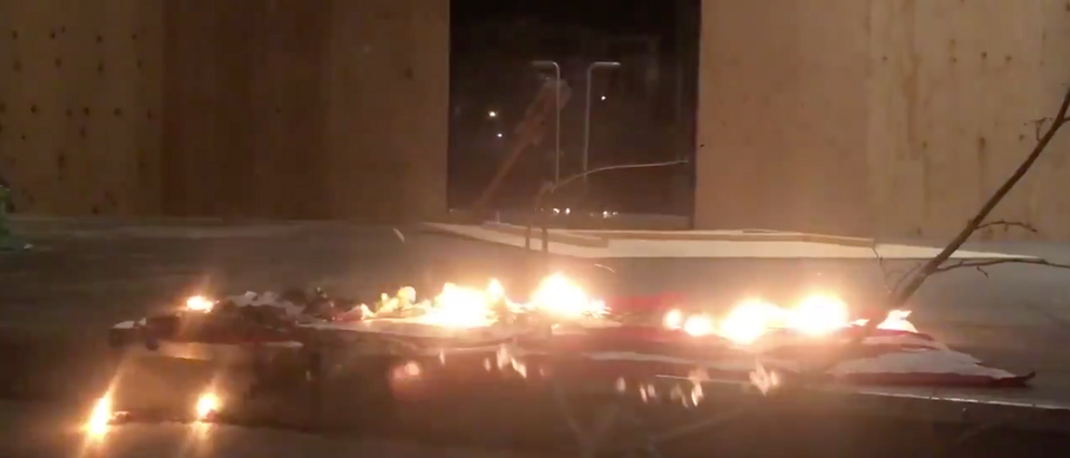 Protesters burn an American flag outside the Portland courthouse Thursday night [Twitter/Screenshot/Public User Garrison Davis]