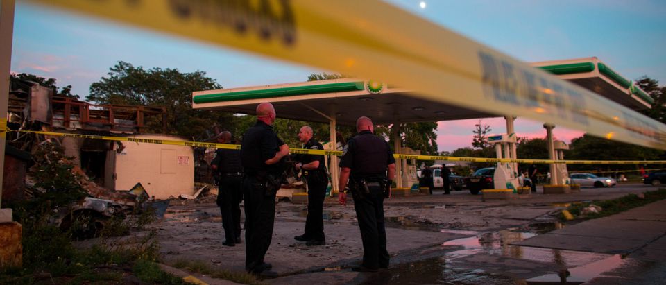 Police officers at a gas station. Photo by Darren hauck. Getty.