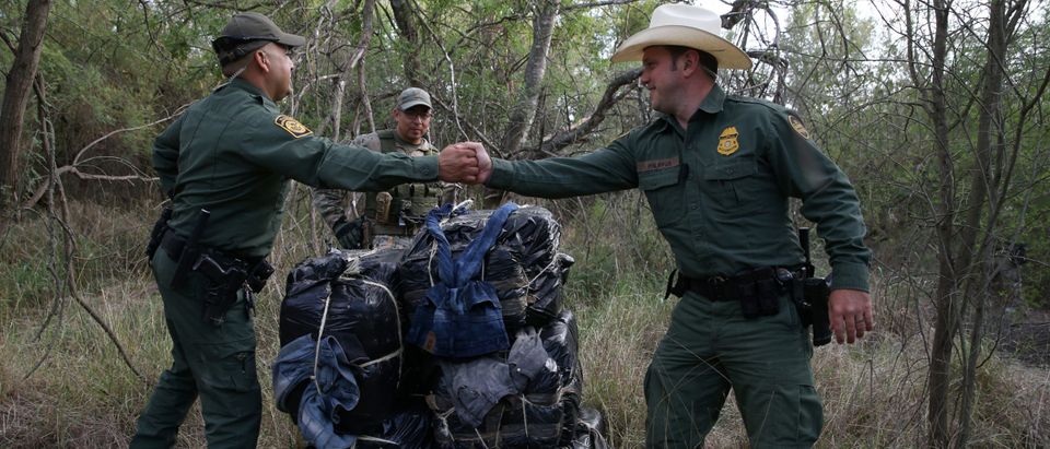 Border patrol agents congratulate each other after seizing 297 pounds of marijuana following a drug bust by the Mexico-U.S. border near McAllen