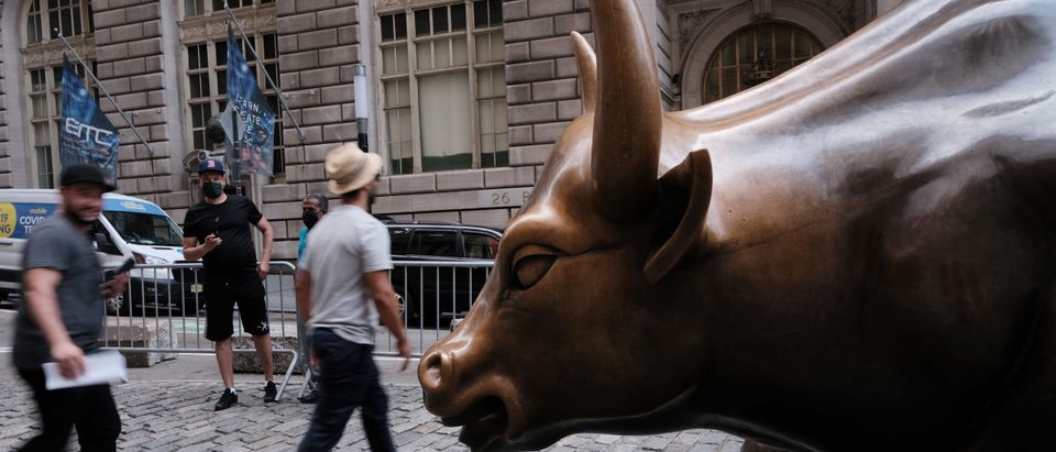 People walk by the Wall Street Bull near the New York Stock Exchange (NYSE) on August 10, 2021 in New York City. (Photo by Spencer Platt/Getty Images)