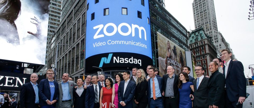 Zoom founder Eric Yuan poses with members of his company in front of the Nasdaq building as the screen shows the logo of the video-conferencing software company Zoom. (Kena Betancur/Getty Images)
