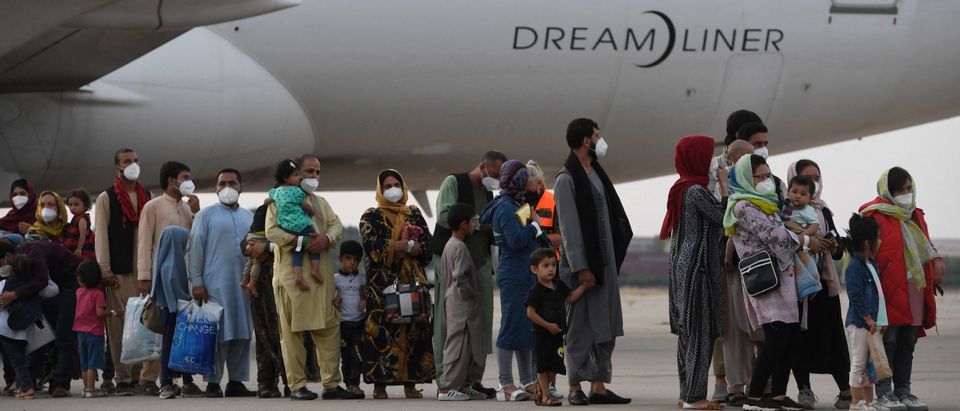 TOPSHOT - Refugees queue on the tarmac after disembarking from an evacuation flight from Kabul, at the Torrejon de Ardoz air base, 30 km from Madrid, on August 24, 2021. - Spain has been evacuating its nationals and local contractors from Afghanistan via Dubai since the Taliban swept to power ten days ago. Another 420 people are expected to arrive in Spain on August 24, 2021, including 290 people from Dubai and 130 who are expected to leave on a Spanish military plane from Kabul. (Photo by PIERRE-PHILIPPE MARCOU / AFP) (Photo by PIERRE-PHILIPPE MARCOU/AFP via Getty Images)