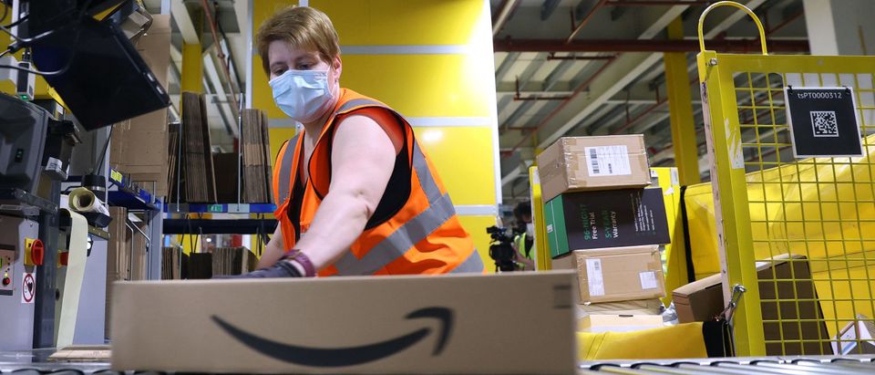 An employee prepares a package for shipment at the Amazon logistics centre in Suelzetal near Magdeburg, eastern Germany, on Mai 12, 2021. (Photo by RONNY HARTMANN/AFP via Getty Images)