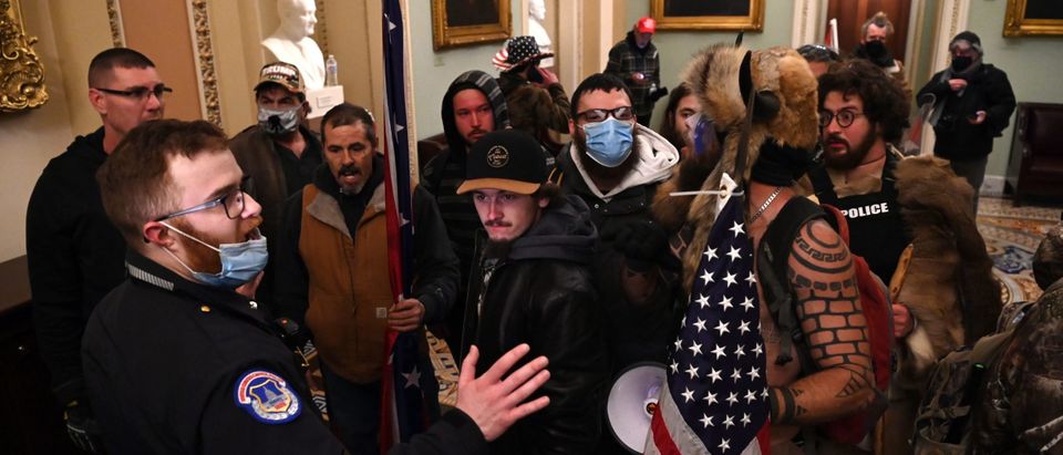 Supporters of US President Donald Trump, including Jake Angeli, a QAnon supporter known for his painted face and horned hat, protest in the US Capitol on January 6, 2021, in Washington, DC. - Demonstrators breeched security and entered the Capitol as Congress debated the a 2020 presidential election Electoral Vote Certification. (Photo by Saul LOEB / AFP) (Photo by SAUL LOEB/AFP via Getty Images)