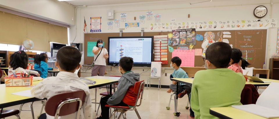 Melissa Wong, a teacher at Yung Wing School P.S. 124 gives a lesson to her masked students in their classroom on September 27, 2021 in New York City. (Photo by Michael Loccisano/Getty Images)