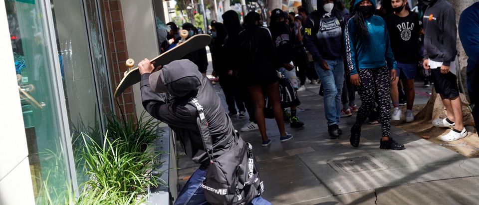 LOS ANGELES, CA - MAY 31: A man attempts to break the window of a store with a skateboard during widespread protests and unrest in response to the death of George Floyd on May 31, 2020 in Santa Monica, California. Protests continue in cities throughout the country after Floyd died in police custody in Minneapolis. The National Guard has been deployed in Los Angeles and other major US cities to attempt to stem the tide of rising violence and unrest, with President Donald Trump blaming ANTIFA and tweeting they will be designated a terrorist organization. (Photo by Warrick Page/Getty Images)