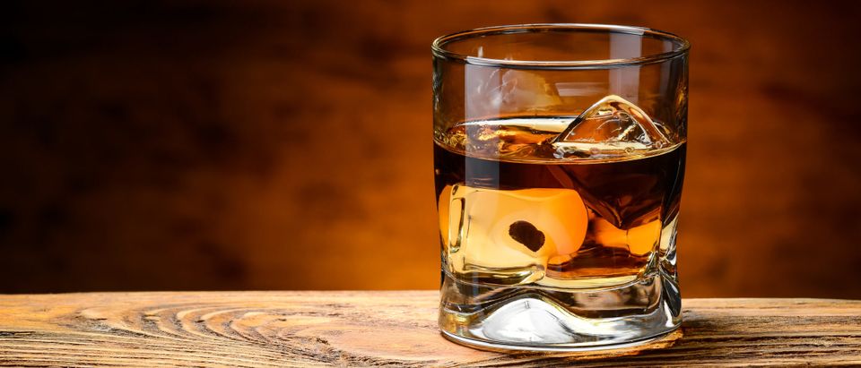 Whiskey with ice on a wooden table [Shutterstock/Ruslan Semichev]