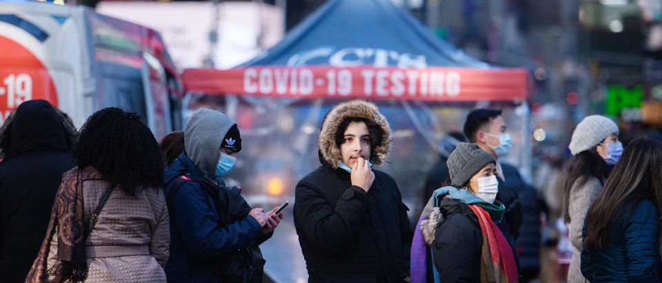 People queue at a street-side Covid-19 testing booth in New York's Times Square on December 20, 2021. - On December 18, New York state announced a record number of daily cases for the second day in a row with almost 22,000 positive results. (Photo by Ed JONES / AFP) (Photo by ED JONES/AFP via Getty Images)