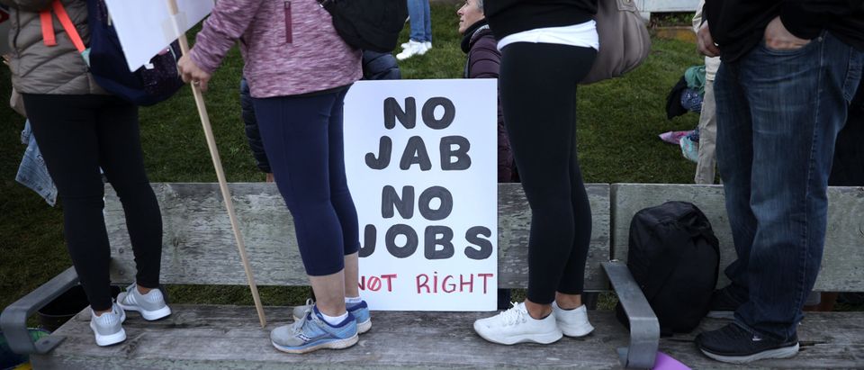 Protesters stand next to a sign during an anti-vaccination rally at the Golden Gate Bridge on November 11, 2021 in San Francisco, California. Protesters against the COVID-19 vaccination gathered at the Golden Gate Bridge to rally against vaccine mandates. (Photo by Justin Sullivan/Getty Images)