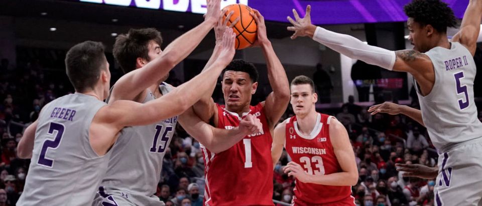 Jan 18, 2022; Evanston, Illinois, USA; Northwestern Wildcats center Ryan Young (15) defends Wisconsin Badgers guard Johnny Davis (1) during the first half at Welsh-Ryan Arena. Mandatory Credit: David Banks-USA TODAY Sports via Reuters