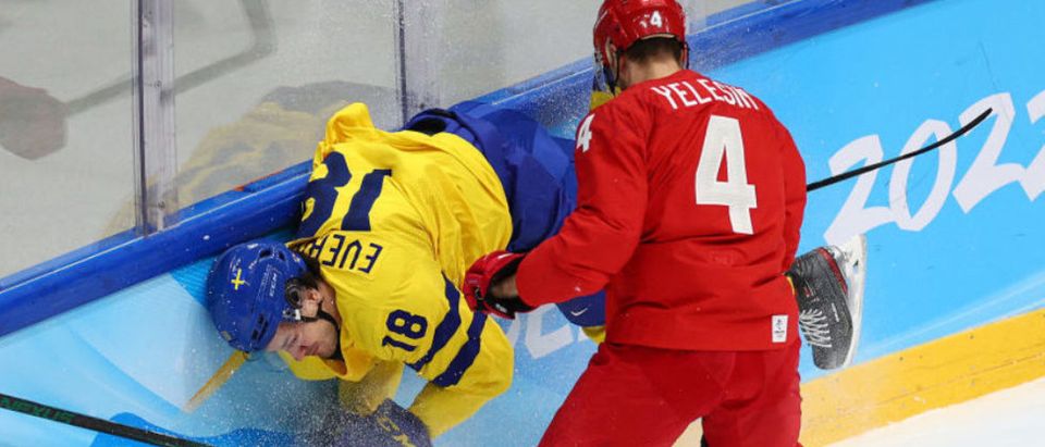 BEIJING, CHINA - FEBRUARY 18: Dennis Everberg #18 of Team Sweden is checked by Alexander Yelesin #4 of Team ROC in the first period during the Men's Ice Hockey Playoff Semifinal match between Team ROC and Team Sweden on Day 14 of the Beijing 2022 Winter Olympic Games at National Indoor Stadium on February 18, 2022 in Beijing, China. (Photo by Elsa/Getty Images)