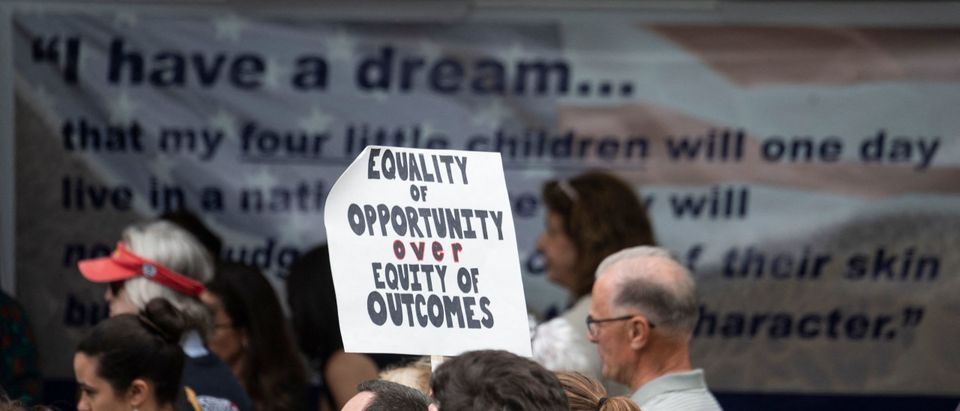 A participant holds up a sign during a rally against "critical race theory" (CRT) being taught in schools at the Loudoun County Government center in Leesburg, Virginia on June 12, 2021.(Photo by ANDREW CABALLERO-REYNOLDS/AFP via Getty Images)