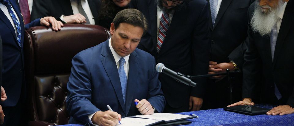 Florida Gov. Ron DeSantis signs two bills at the Shul of Bal Harbour on June 14, 2021 in Surfside, Florida. The bills are HB 529 and HB 805. HB 805 ensures that volunteer ambulance services, including Hatzalah, can operate. HB 529 requires Florida schools to hold a daily moment of silence. (Photo by Joe Raedle/Getty Images)