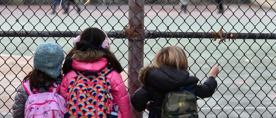 Children look at their school ground as they wait for class on the first day of school reopening on December 7, 2020 in the Brooklyn borough of New York City. (Photo by ANGELA WEISS/AFP via Getty Images)