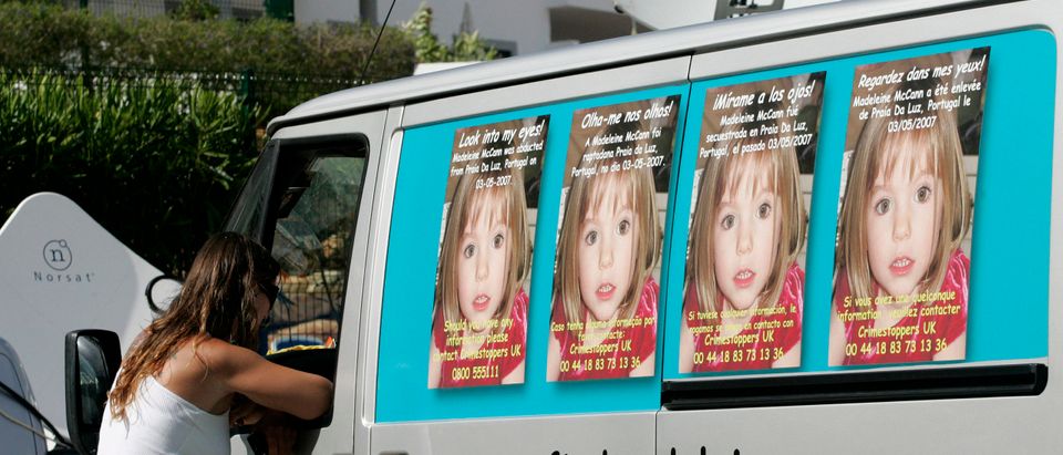 A woman talks with driver of a van carrying posters of the campaign to find missing girl Madeleine McCann on the beach resort of Lagos