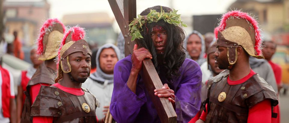 A man playing the role of Jesus Christ is escorted during a ritual procession re-enacting the death of Jesus Christ in Lagos
