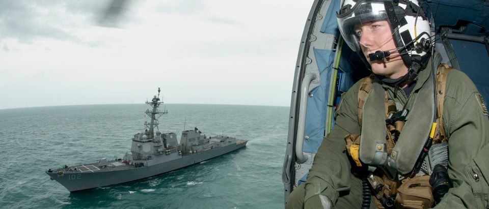 Naval Aircrewman 2nd Class Cody Witherspoon, assigned to Helicopter Maritime Strike Squadron (HSM) 35, keeps a lookout in the Java Sea as his helicopter returns to the guided-missile destroyer USS Sampson January 6, 2015. (REUTERS/U.S. Navy/Mass Communication Specialist 1st Class Brett Cote/Handout via Reuters)